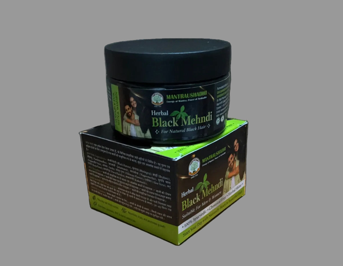 A jar of Mantri Naturals Herbal Black Mehndi placed on top of its retail box, set on a brown cardboard box against a gray wall.